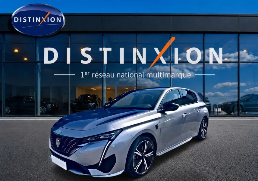 Peugeot 308 1.2 hybrid gris vue 3/4 avant droit, jantes alu et phares LED devant showroom Distinxion.