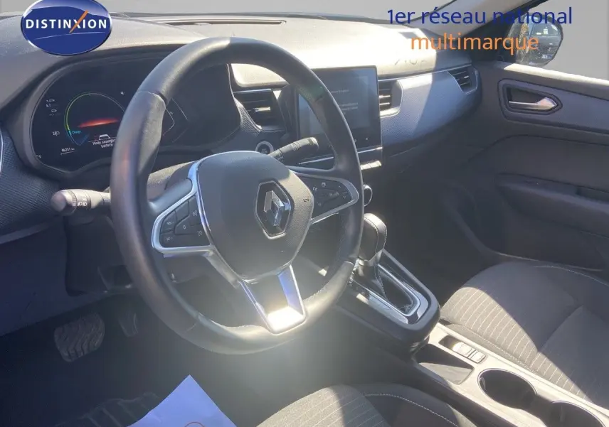 Vue intérieure du poste de conduite du Renault Arkana noir métal 2023, volant multifonction et console centrale avec boîte auto.