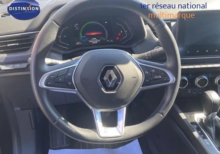 Vue rapprochée du volant noir de la Renault Arkana hybride 2023 avec tableau de bord numérique et console centrale visible.