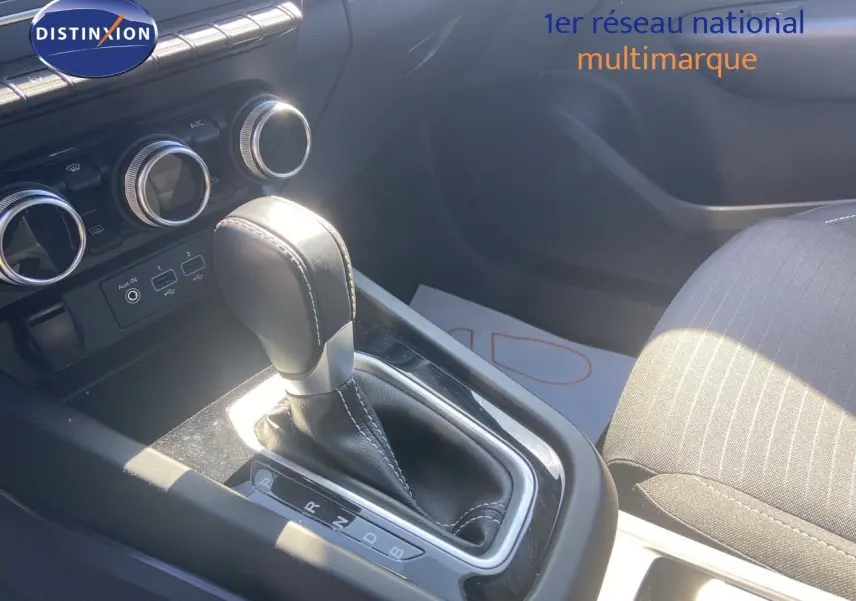 Le levier de vitesse automatique noir et argenté du Renault Arkana 2023, avec la console centrale et sièges en tissu gris.