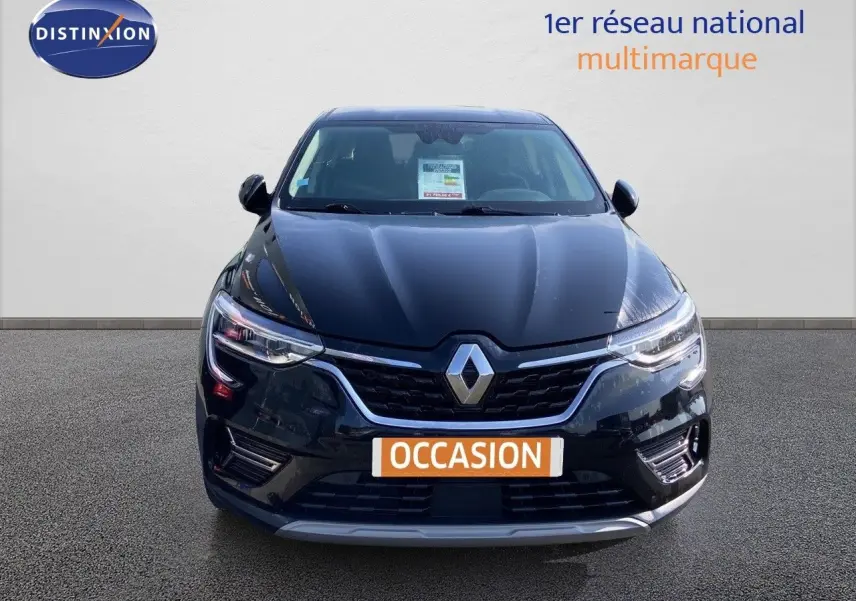 Vue frontale d'un Renault Arkana noir métal 2023 avec éclairage LED et badge distinctif au centre de la calandre.