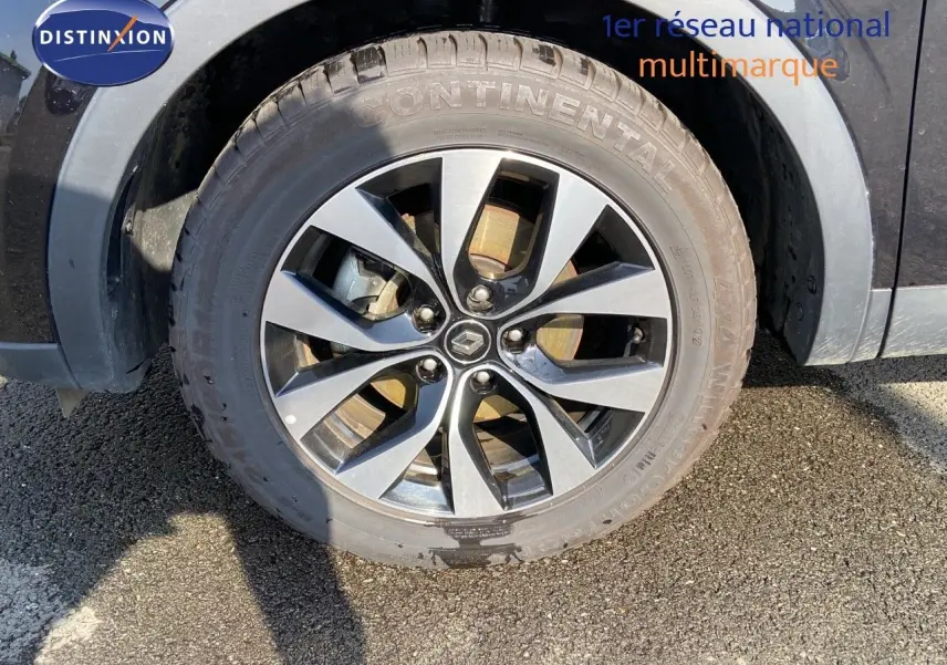 Gros plan sur la roue avant gauche noire métal d'un Renault Arkana hybride 2023 avec jante bi-ton distinctive.