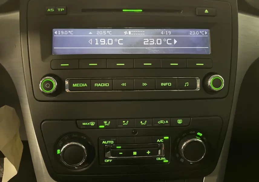 Tableau de bord du Skoda Yeti 2015 montrant la console centrale avec climatisation automatique bi-zone et commandes audio éclairées en vert
