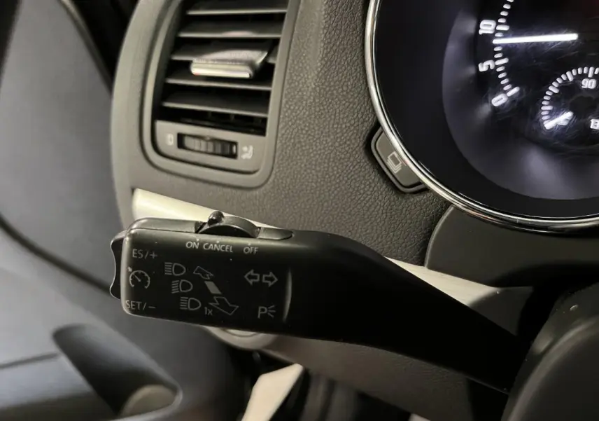 Gros plan sur la commande de régulateur de vitesse à gauche du tableau de bord noir du Skoda Yeti 2015.