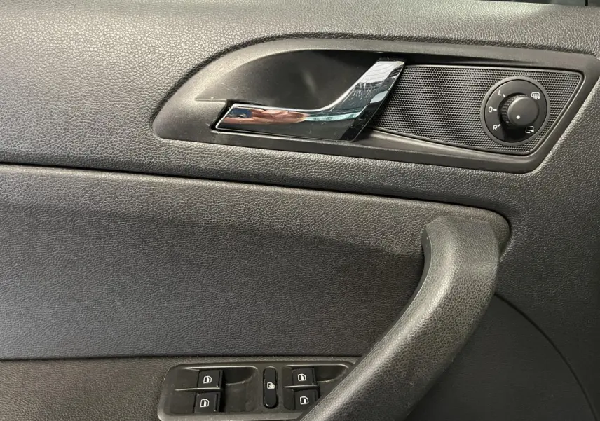 Détail de la porte côté conducteur du Skoda Yeti 2015 noire, avec commandes des vitres et réglage des rétroviseurs.