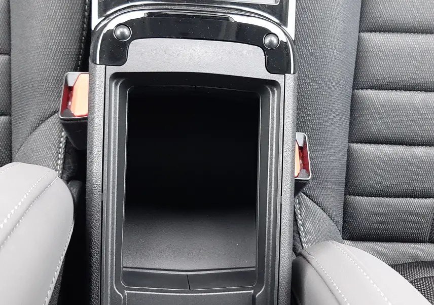 Vue plongeante sur la console centrale noire et les sièges gris foncé du Citroën C4 hybride 2025.