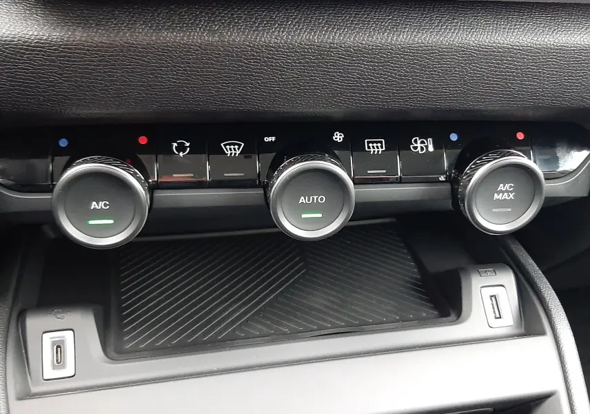 Gros plan sur la console centrale du Citroën C4 2025 blanc Okenite avec commandes climatisation et ports USB visibles.