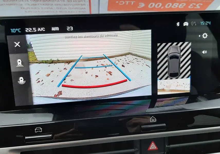 Affichage de la caméra de recul sur l'écran central d'une Citroën C4 blanche avec toit noir, vue intérieure du tableau de bord.