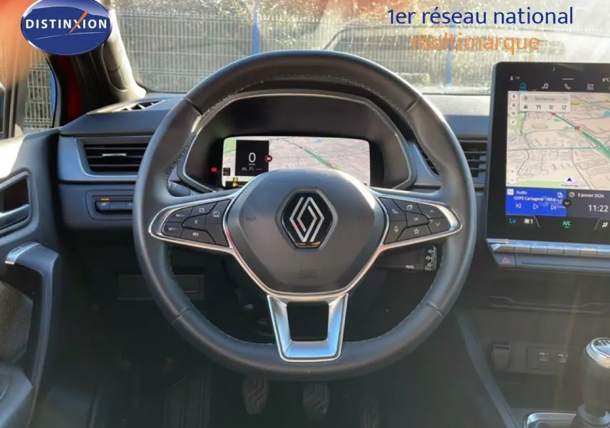 Vue frontale de l'intérieur du Renault Captur 2025, volant cuir noir avec tableau de bord numérique et écran tactile.