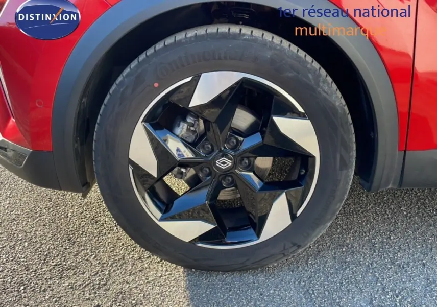 Gros plan sur la roue avant gauche du Renault Captur rouge Désir Métal avec jante noire et argentée au design moderne.