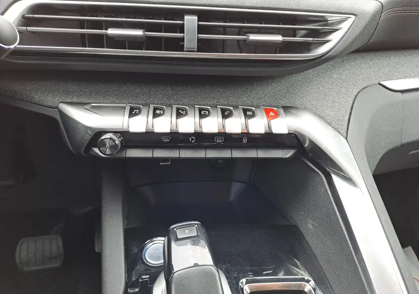 Gros plan sur la console centrale du Peugeot 3008 blanc, mettant en valeur les commandes et le levier de boîte automatique.