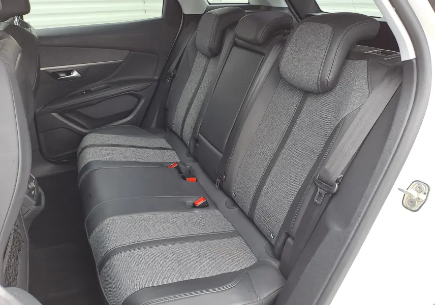 Vue intérieure côté droit des sièges arrière gris tissu et cuir du Peugeot 3008 blanc de 2018.