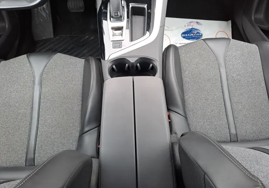 Vue plongeante sur la console centrale et les sièges avant gris et noir du Peugeot 3008 blanc 2018.