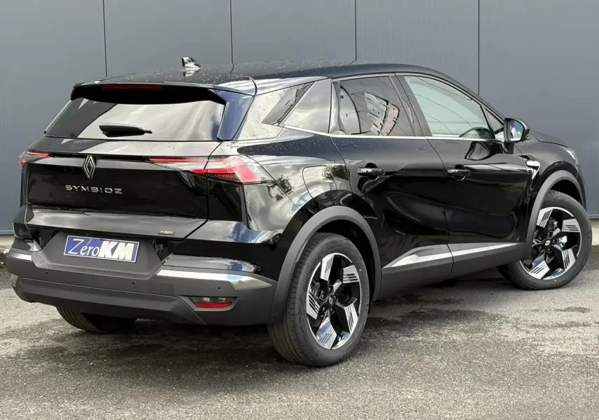 Renault Symbioz noir étoile en 3/4 arrière droit, jantes 18 pouces et antenne requin noir brillant visible.