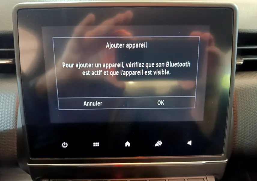 Écran tactile central affichant un message Bluetooth dans l'habitacle d'une Renault Clio Business blanche de 2020.