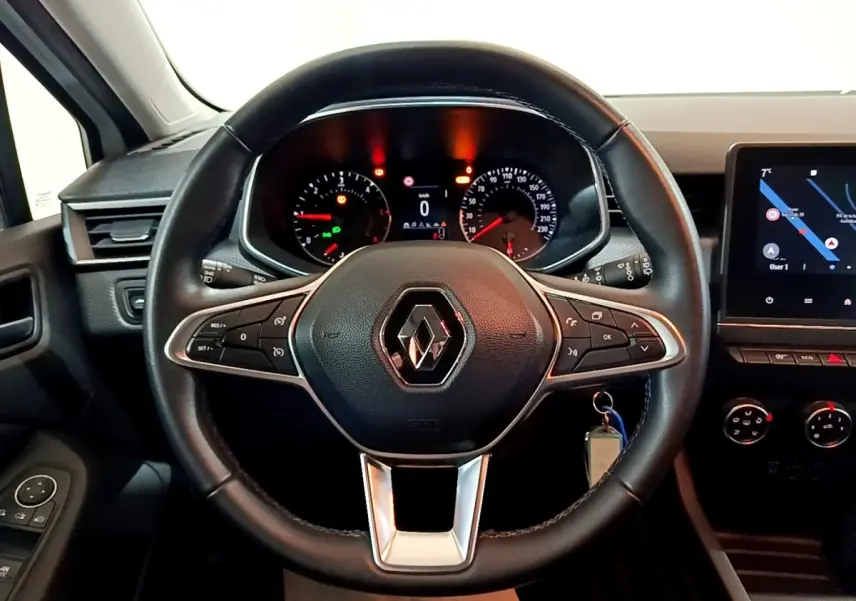 Vue frontale du volant cuir noir de la Renault Clio Business Blue dCi 85 avec tableau de bord et écran tactile allumé.