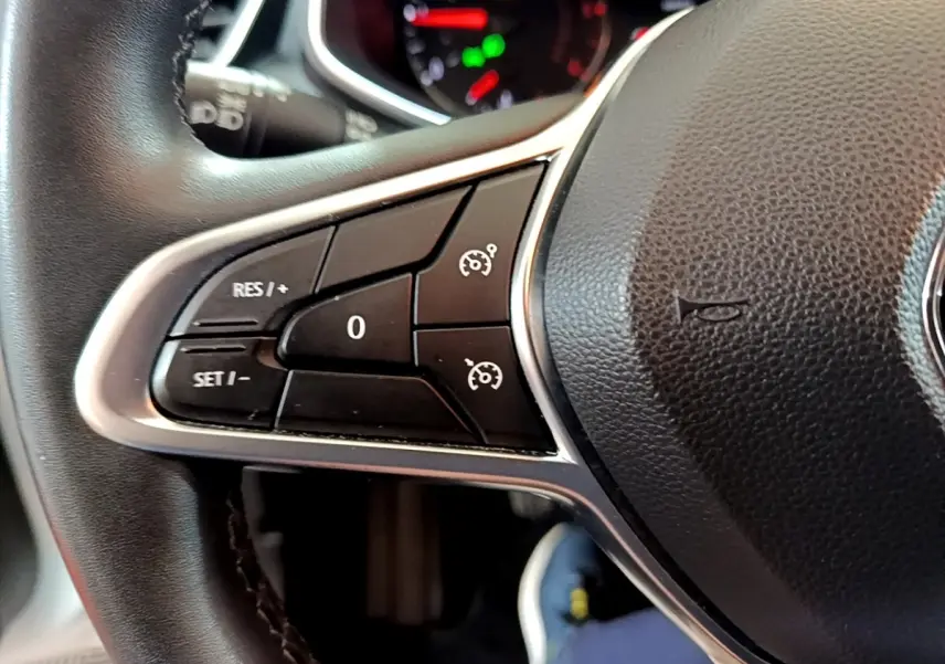 Gros plan sur les commandes du régulateur de vitesse au volant cuir noir de la Renault Clio Business Blue dCi 2020.