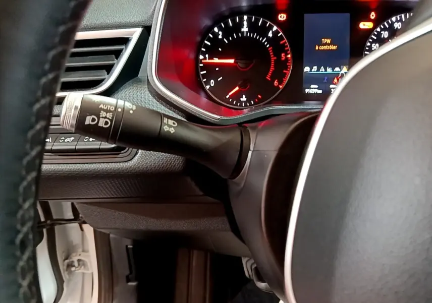 Gros plan sur le tableau de bord et le volant de la Renault Clio Business Blue dCi 85 blanc, avec affichage digital et commandes au volant.