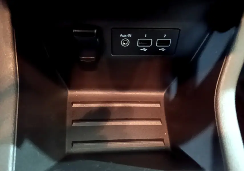 Gros plan sur la console centrale noire de la Renault Clio Business Blue dCi 85 avec prises USB et Aux-In visibles.