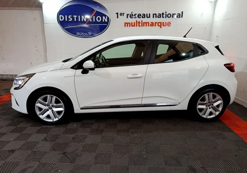 Profil côté gauche d'une Renault Clio Business Blue dCi 85 blanche, avec jantes alliage et logo Distinxion en arrière-plan.