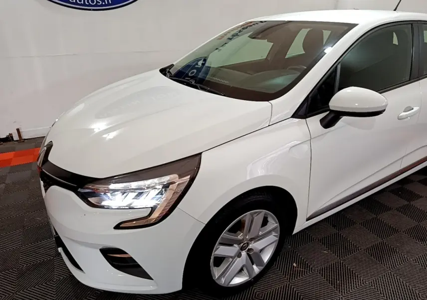 Renault Clio Business blanc vue 3/4 avant droit, phares LED allumés et jantes alliage visibles.