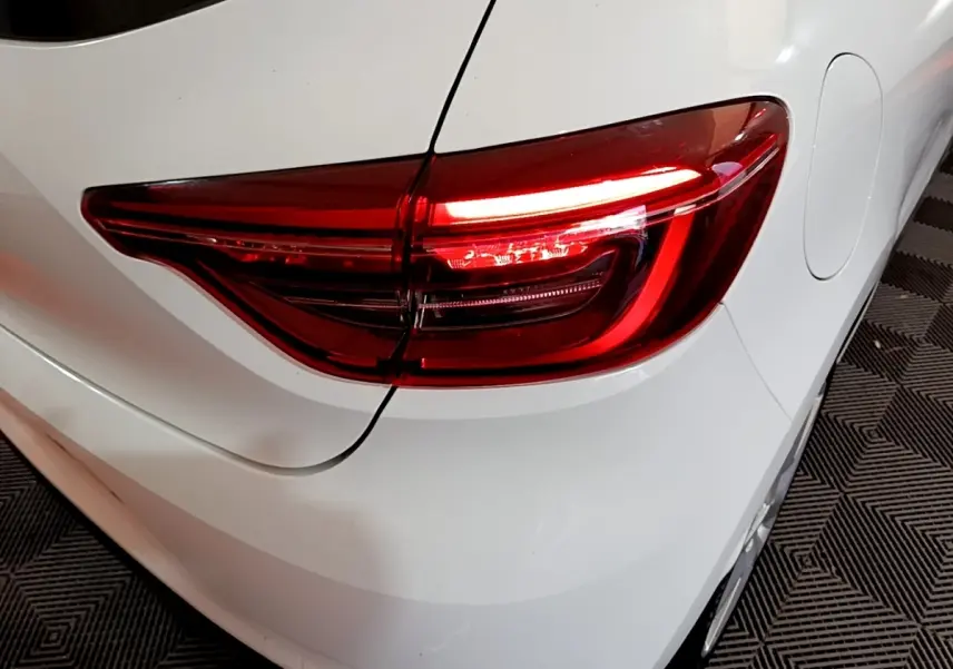 Gros plan sur le feu arrière droit rouge d'une Renault Clio Business Blue dCi 85 blanche de 2020.