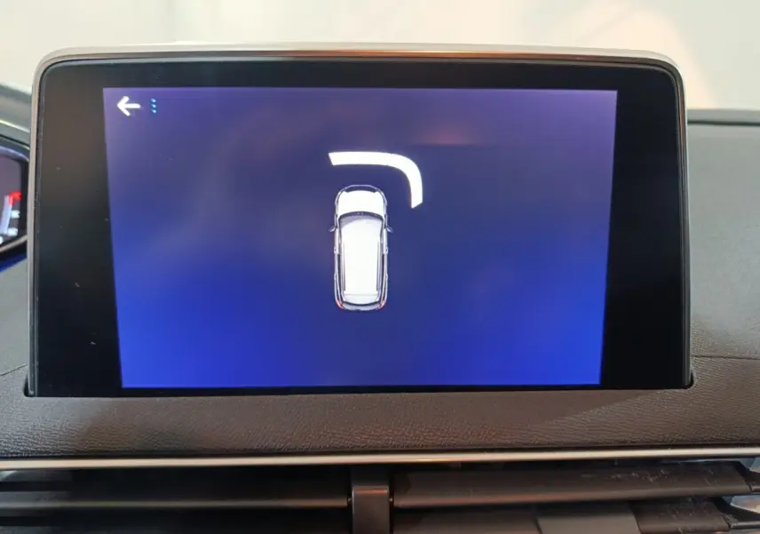 Écran tactile intérieur du Peugeot 3008 affichant la vue de dessus du véhicule avec indication de braquage.