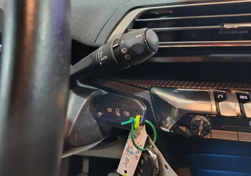 Gros plan sur la clé de contact insérée côté gauche du tableau de bord noir du Peugeot 3008 2020 diesel.