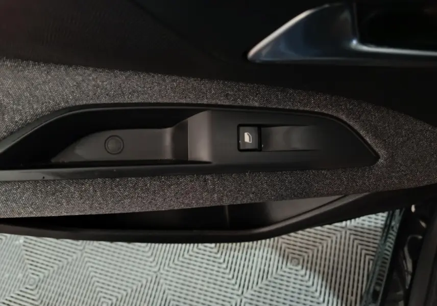 Gros plan sur la commande de verrouillage de porte côté gauche avec garniture tissu gris foncé dans un Peugeot 3008 2020.