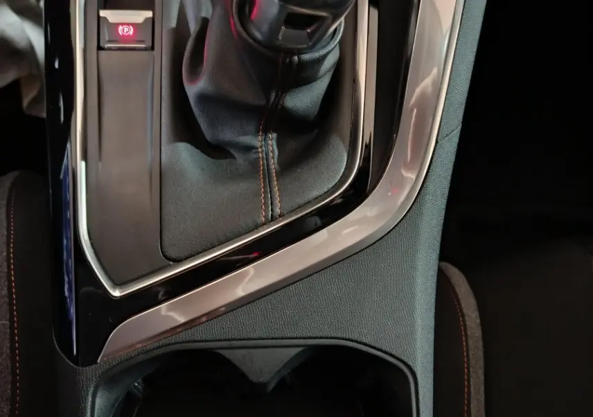 Gros plan sur la commande de boîte manuelle et frein à main électrique dans l'habitacle sombre du Peugeot 3008 2020.