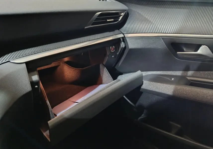 Vue intérieure côté passager du Peugeot 3008 2020 avec boîte à gants ouverte et tableau de bord noir texturé.
