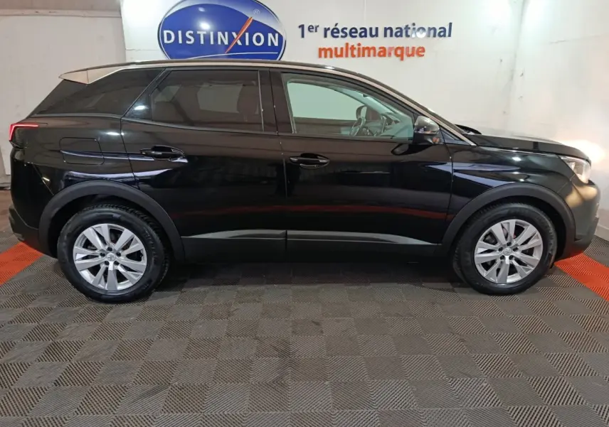 Profil côté gauche d'un Peugeot 3008 noir 2020 garé en intérieur avec jantes alliage et vitres teintées.