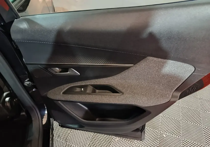 Vue rapprochée de la porte avant gauche du Peugeot 3008 2020 avec garniture noire et grise texturée.