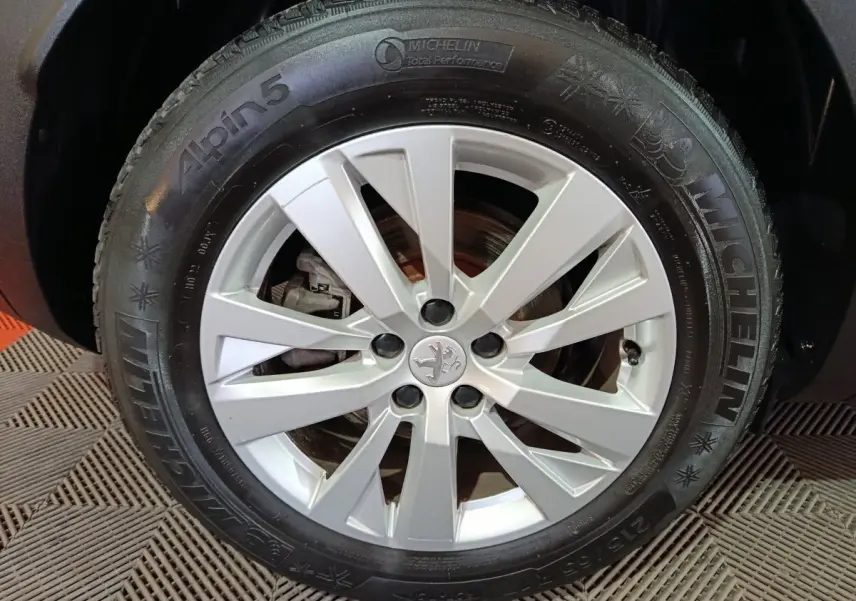Gros plan sur la roue avant droite du Peugeot 3008 2020 avec jante argentée et pneu Michelin Alpin 5 hiver.