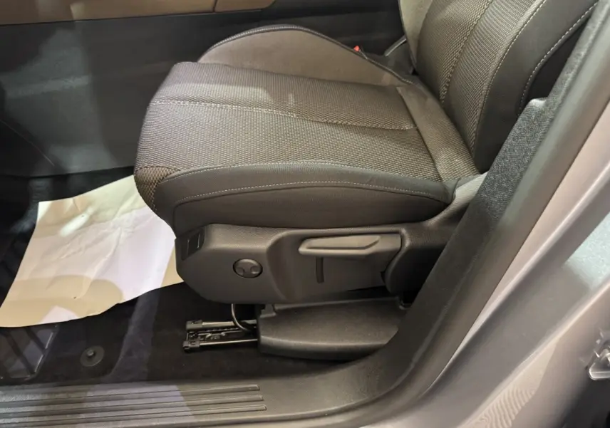 Gros plan sur le siège avant droit gris foncé du DS7 Crossback E-TENSE 225 Bastille+ avec réglages manuels visibles.