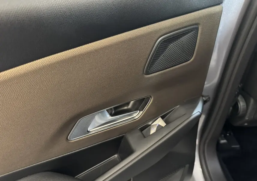 Détail de la porte arrière droite du DS7 Crossback gris foncé, montrant la poignée intérieure et le haut-parleur intégré.