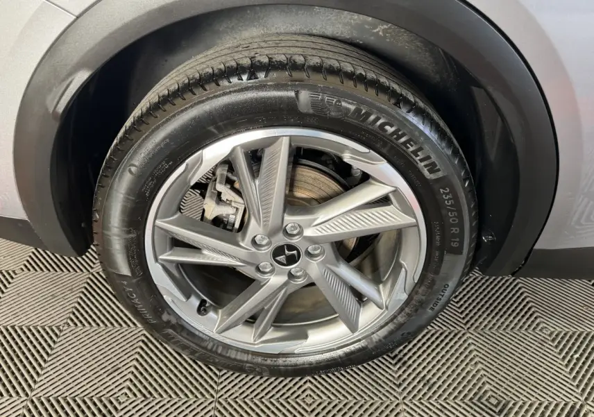 Gros plan sur la roue avant droite gris foncé du DS7 Crossback E-TENSE 225 Bastille+ avec jante alliage et pneu Michelin.
