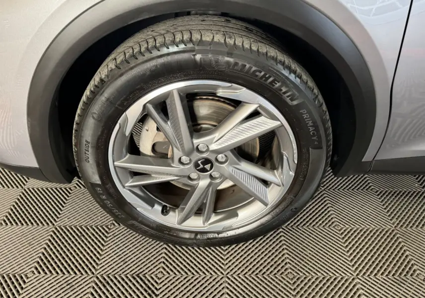 Gros plan sur la roue avant droite gris foncé du DS7 Crossback E-TENSE 225 BASTILLE + avec jante alliage et pneu Michelin.