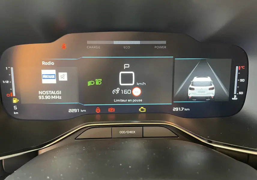 Tableau de bord numérique du Citroën C5 Aircross hybride 2025, affichant la vitesse, radio et caméra de recul.
