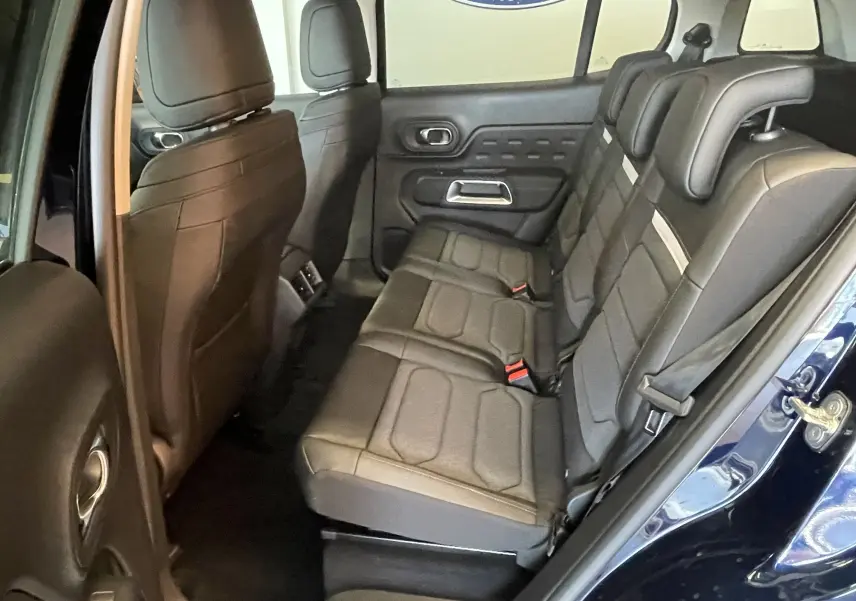 Vue intérieure côté droit des sièges arrière en tissu et TEP du Citroën C5 Aircross hybride 2025 bleu foncé avec portes ouvertes.