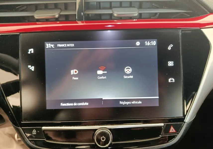Écran tactile central de 10 pouces de l’Opel Corsa rouge 2023 affichant les réglages véhicule et fonctions de conduite.