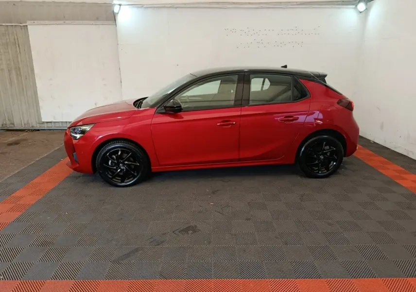 Opel Corsa 1.2 Turbo rouge vue de profil côté gauche avec toit noir et jantes noires brillantes.