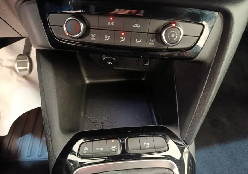 Vue rapprochée de la console centrale noire de l’Opel Corsa 2023, avec commandes climatisation et boutons multifonctions.