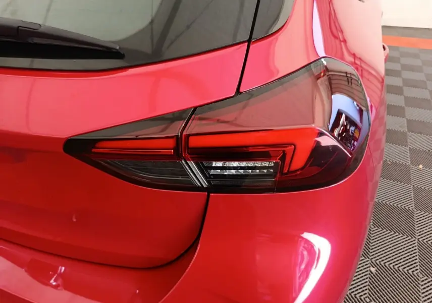 Gros plan sur le feu arrière droit rouge vif d'une Opel Corsa 2023, soulignant les lignes modernes et le vitrage teinté.
