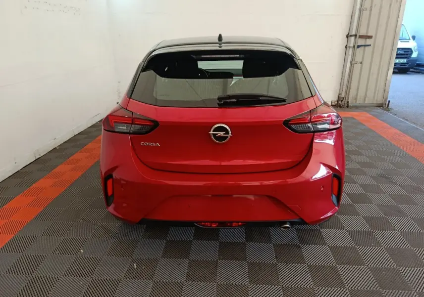 Vue arrière d'une Opel Corsa rouge 2023 avec toit noir, feux arrière LED et logo Opel centré.