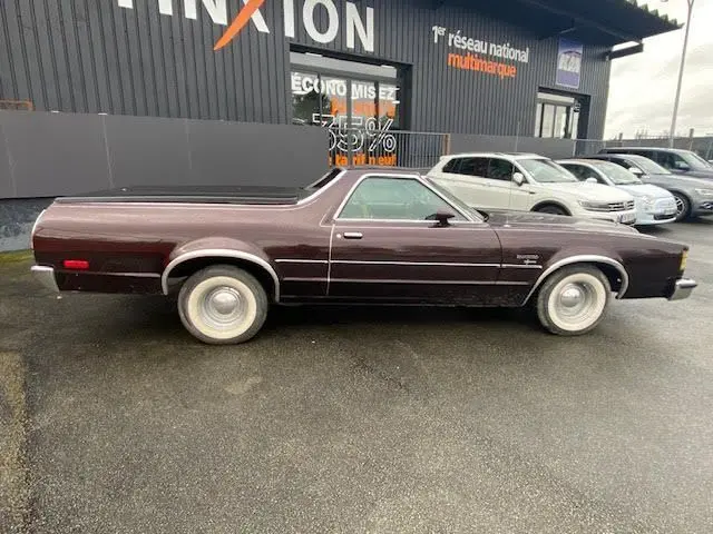 Vue de profil côté gauche d'une Ford Aerostar Ranchero Squire bordeaux métallisé de 1979 avec carrosserie allongée caractéristique.
