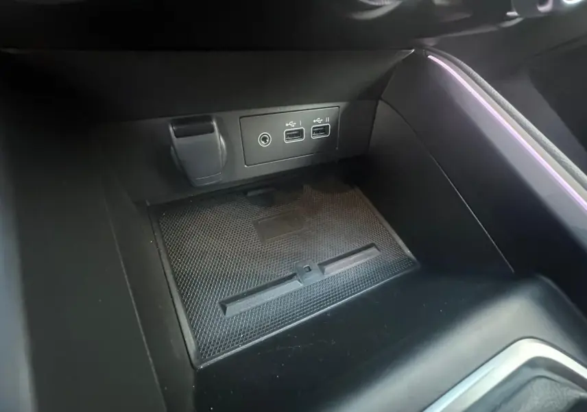 Prise USB double et prise jack dans la console centrale noire de la Renault Clio V Rouge Flamme, éclairage d'ambiance violet.