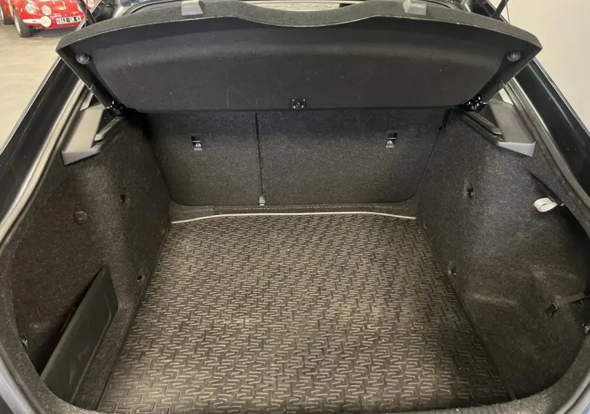 Coffre ouvert vu de face d'une Skoda Octavia gris 2020, avec tapis de sol caoutchouc et fixations ISOFIX.