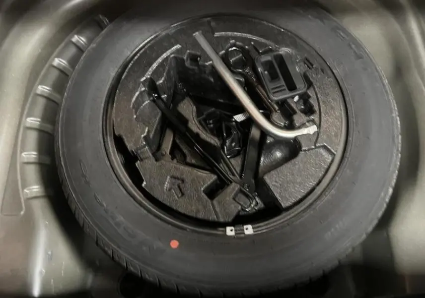 Gros plan sur la roue de secours acier 16 pouces et outils de bord dans le coffre d'une Skoda Octavia gris 2020.