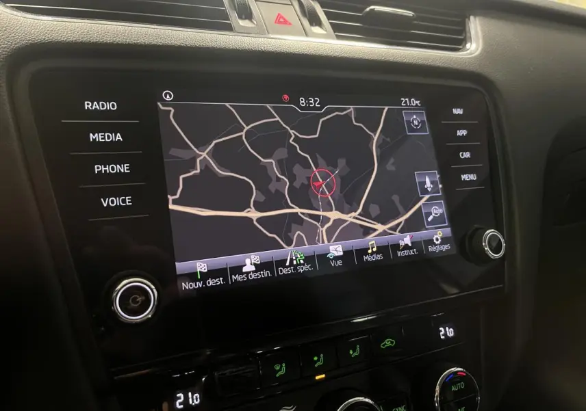 Écran tactile central avec navigation active et commandes climatisation dans une Skoda Octavia gris 2.0 TDI 2020.